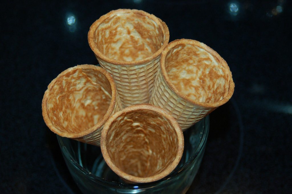 four empty sugar cones standing up in a glass