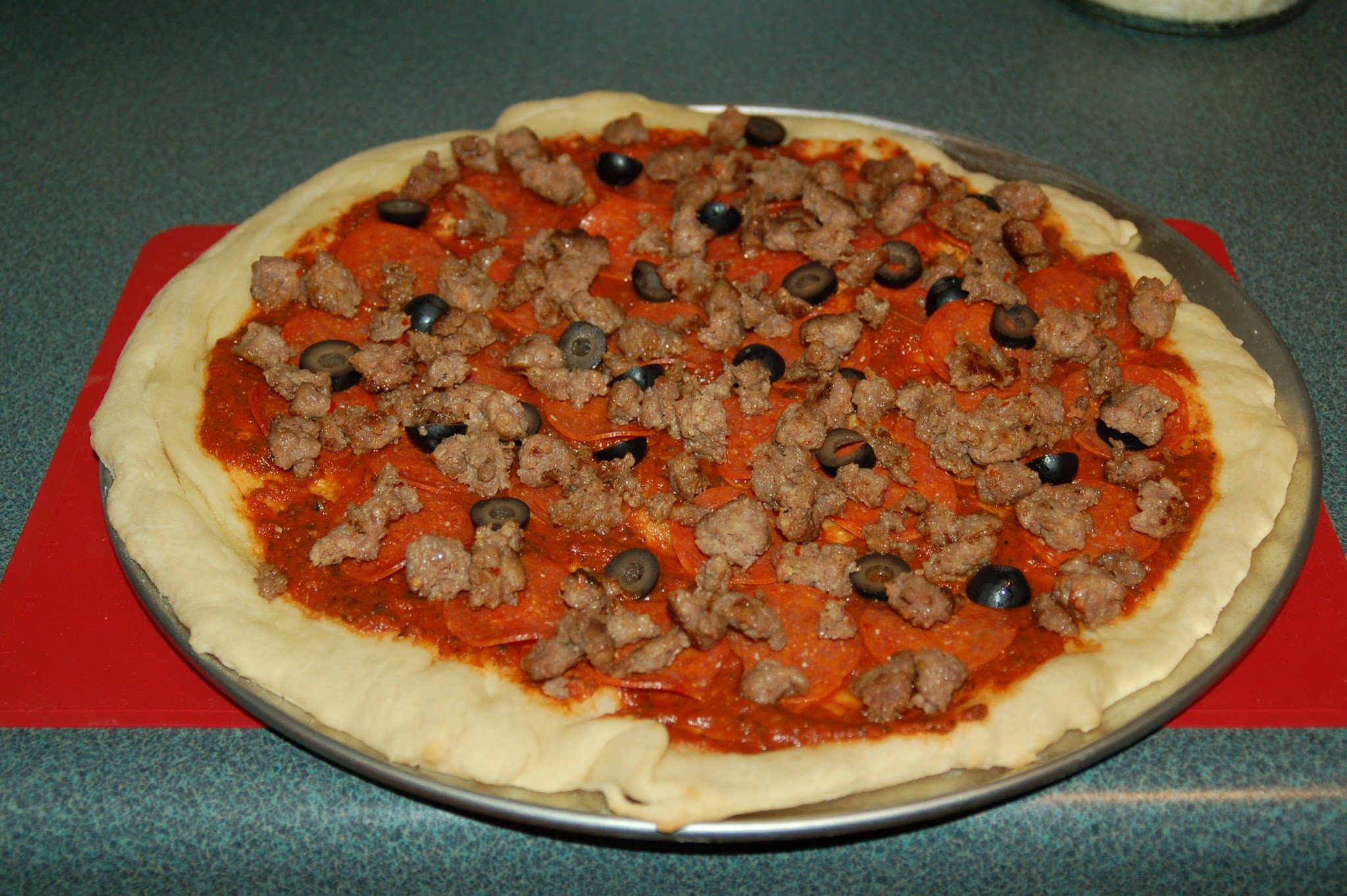 pizza with sausage and ground beef, ready to bake