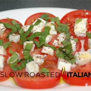 Greek caprese salad on whiteplat