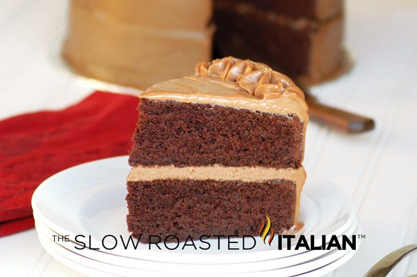 slice of salted caramel chocolate layer cake on white plate.