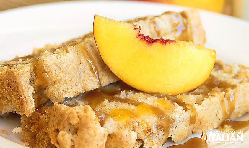 close up photo of 2 slices of pound cake with fresh peaches and caramel sauce