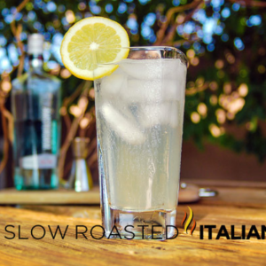 gin fizz cocktail in tall glass with slice of lemon