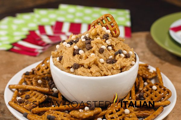 bowl of peanut butter fudge dip on a plate with pretzels for dipping