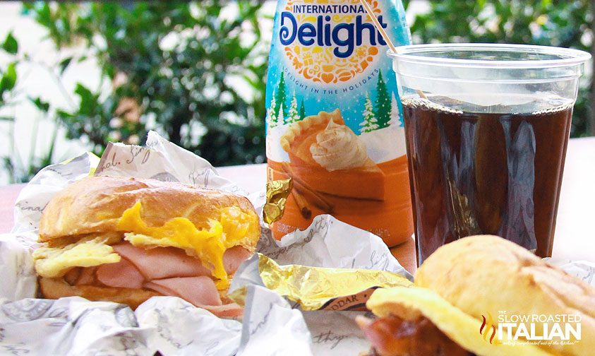 bottle of pumpkin coffee creamer next to cup of coffee