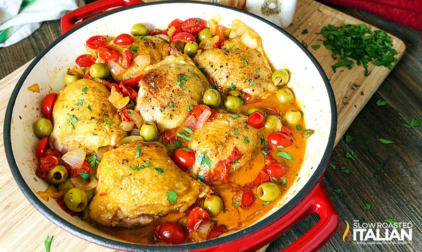 poultry thighs in skillet with olives and tomatoes