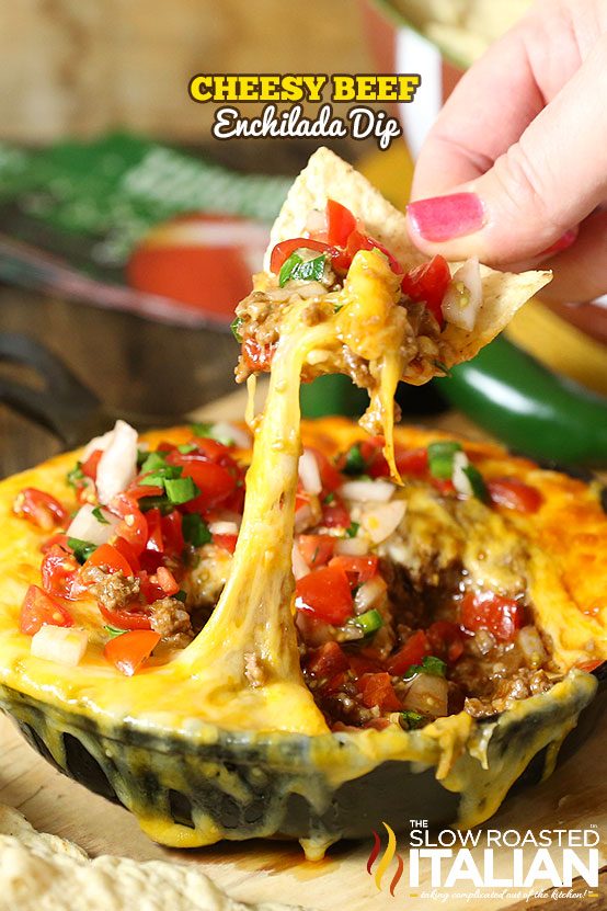 cheesy beef enchilada dip on tortilla chip above bowl