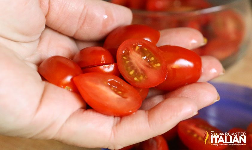 sliced cherry tomatoes in woman's hand