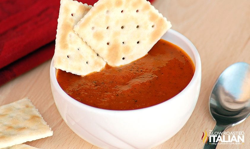 roasted tomato soup in white bowl with saltines