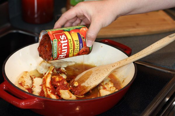 adding tomatoes to italian skillet meal