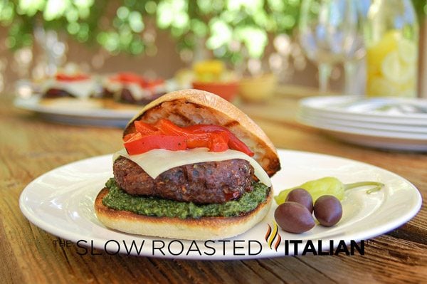 best burger topped with sun dried tomatoes and pesto genovese on toasted ciabatta bun