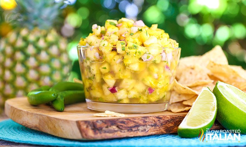 party dip in big glass bowl on wooden serving board with tortilla chips