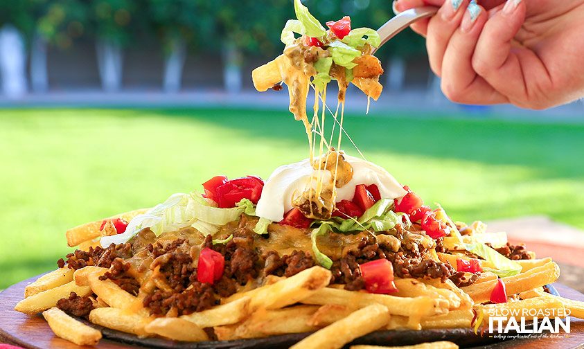 cheesy taco fries on platter and fork