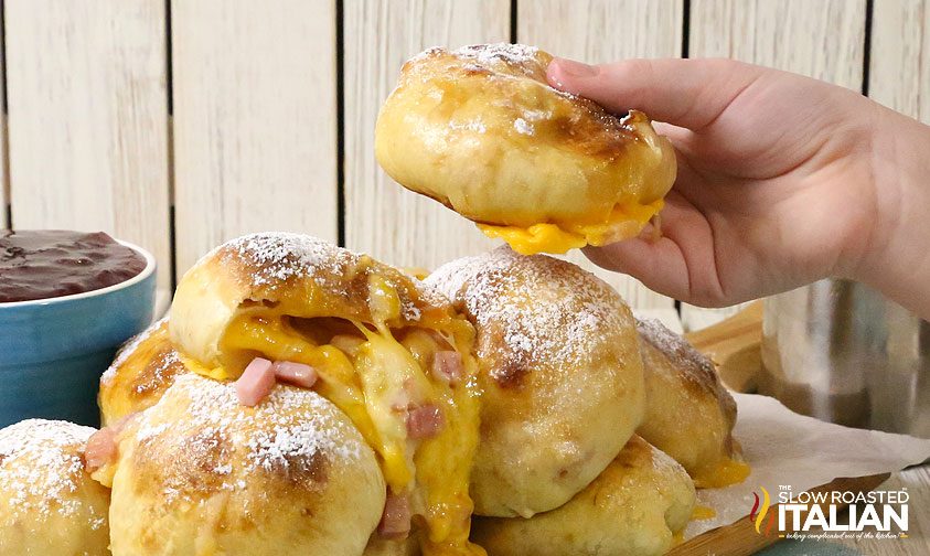 woman's hand holding a turkey, ham and cheese stuffed bread appetizer