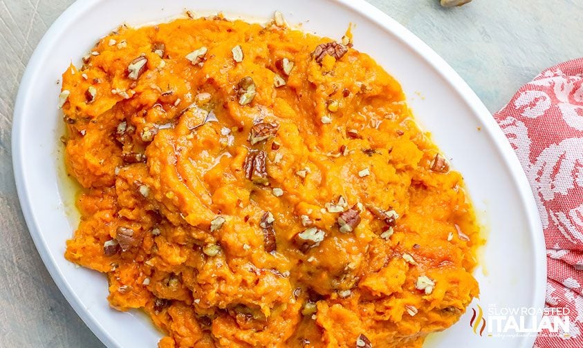 mashed sweet potatoes with brown sugar on a white plate.
