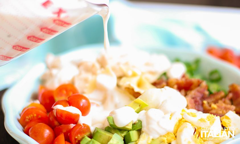 dressing poured on pasta salad