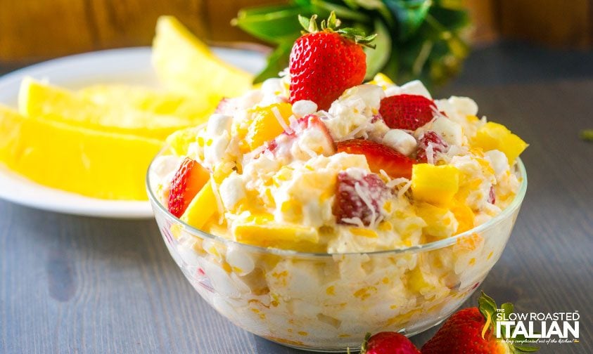strawberry pineapple ambrosia salad in a glass bowl