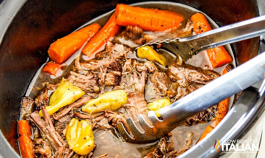 beef cooking in crockpot with carrots and potatoes