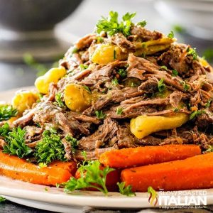 piled of shredded beef chuck roast with carrots and pepperoncini