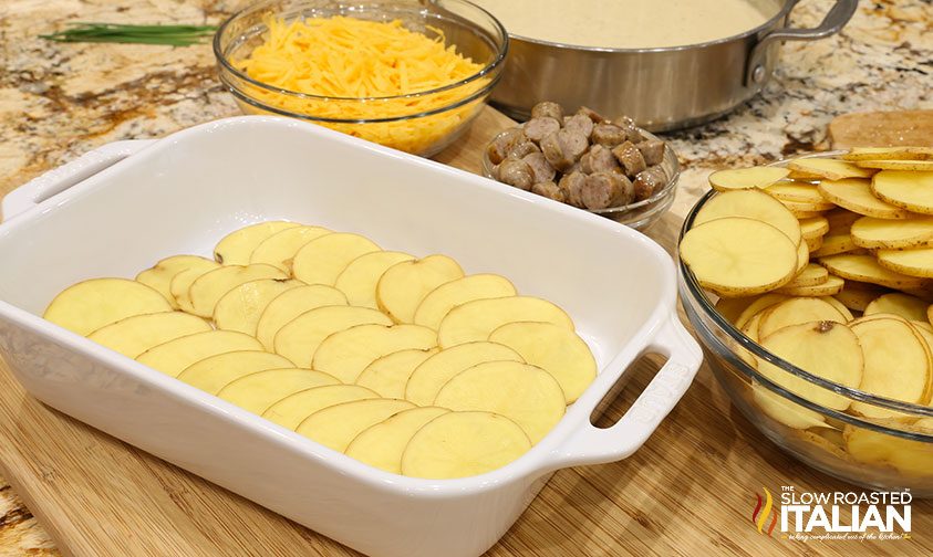 adding potatoes to casserole dish