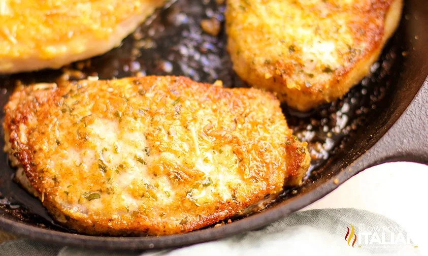 searing pork chops crusted with breadcrumbs and parmesan in cast iron skillet
