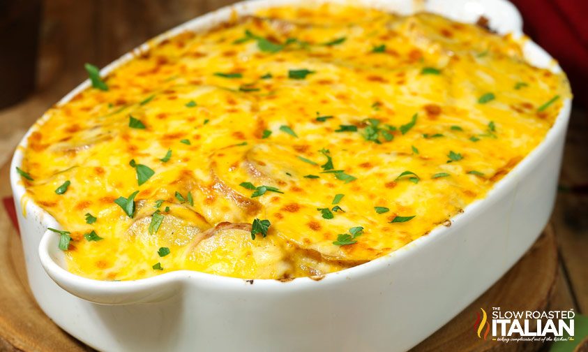 cheesy potatoes au gratin in white casserole dish