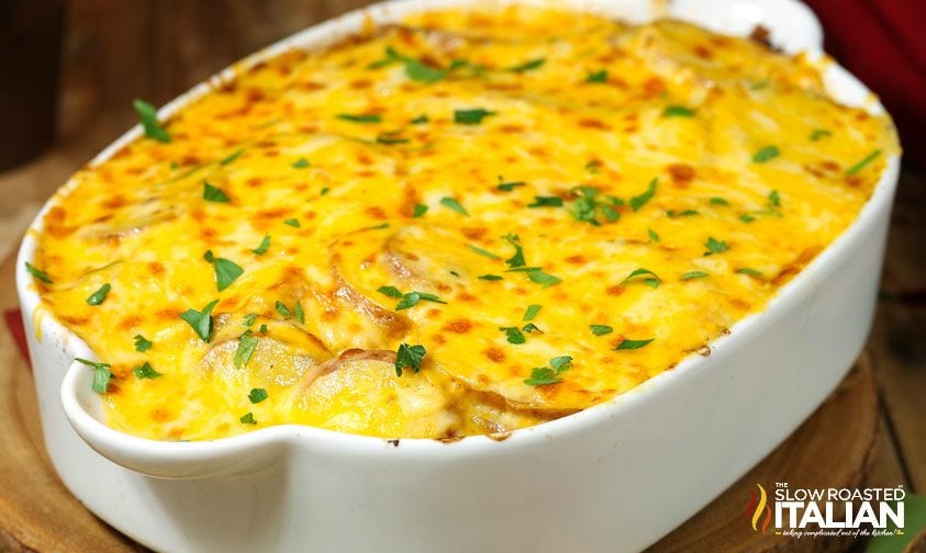 cheesy potatoes au gratin in white casserole dish