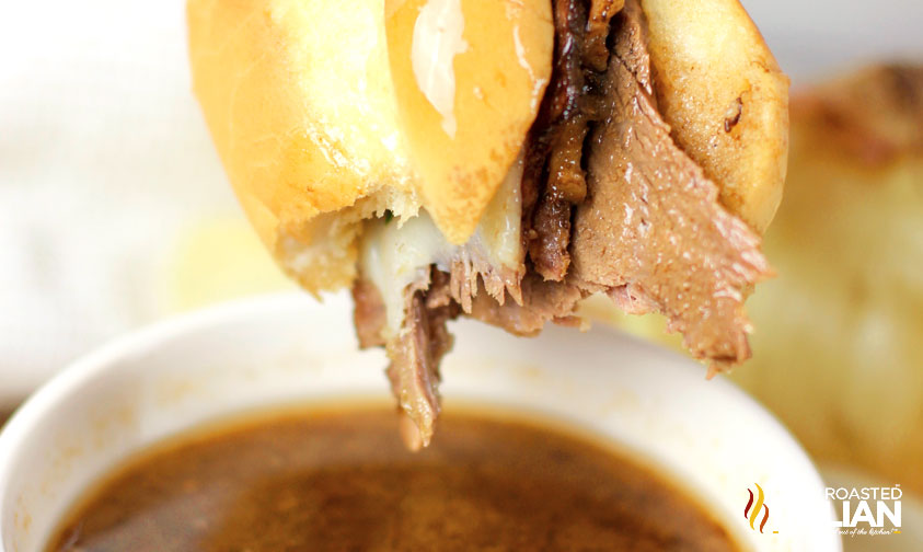 dipping french dip sandwich in au jus