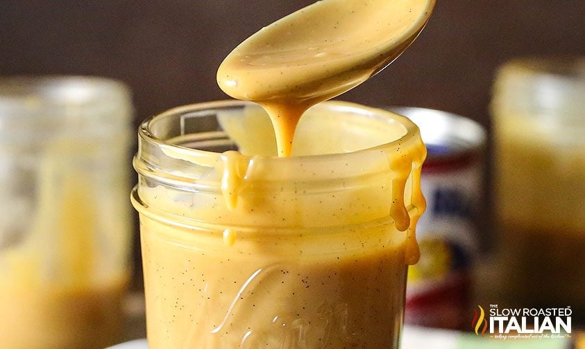 slow cooker dulce de leche dripping from spoon into jar