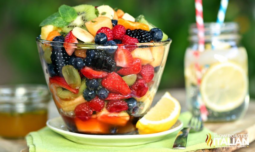 orange honey rainbow fruit salad in glass bowl