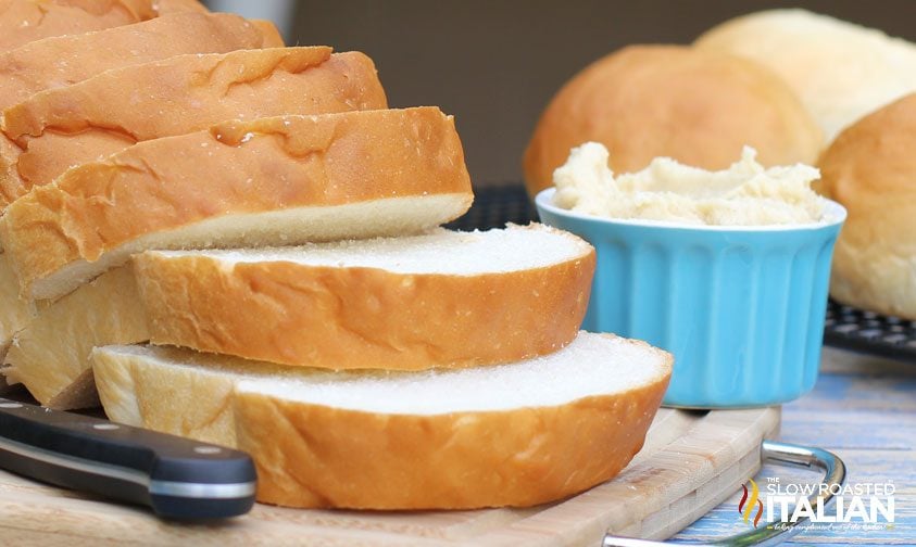 soft slices of homemade bread next to crock of butter
