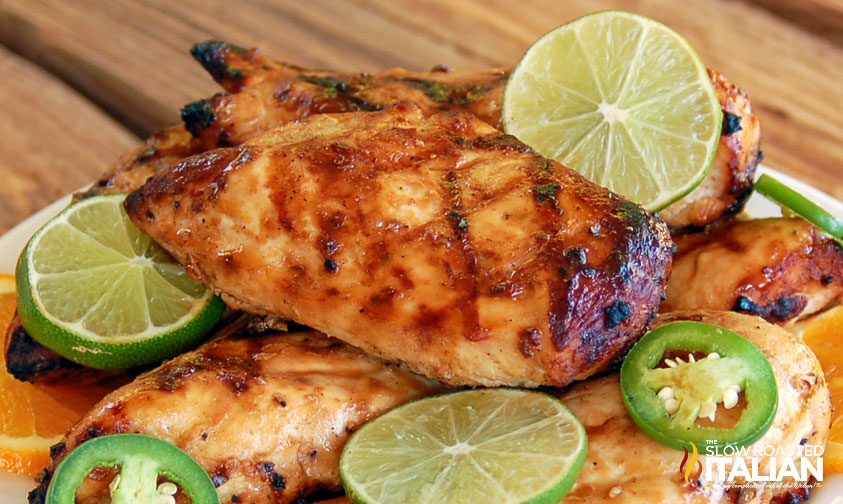 grilled chicken on plate with lime slices and jalapenos