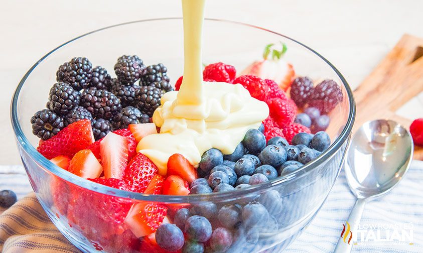 pouring cheesecake filling on fresh fruit