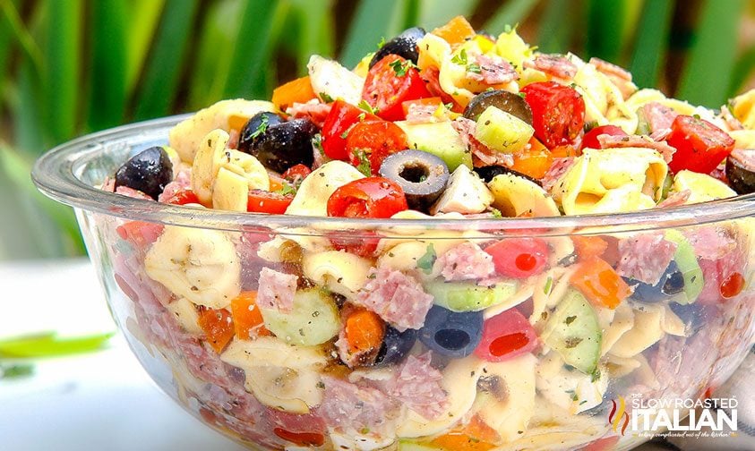 salad with black olives, tomatoes, italian meats and cheese filled pasta