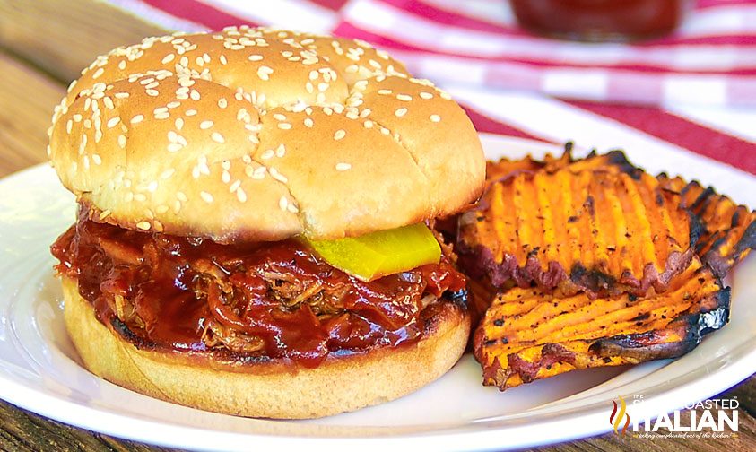 dr pepper pulled pork sandwich on plate with sweet potato chips