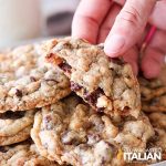 male hand holding chewy rich chocolate chip cookie