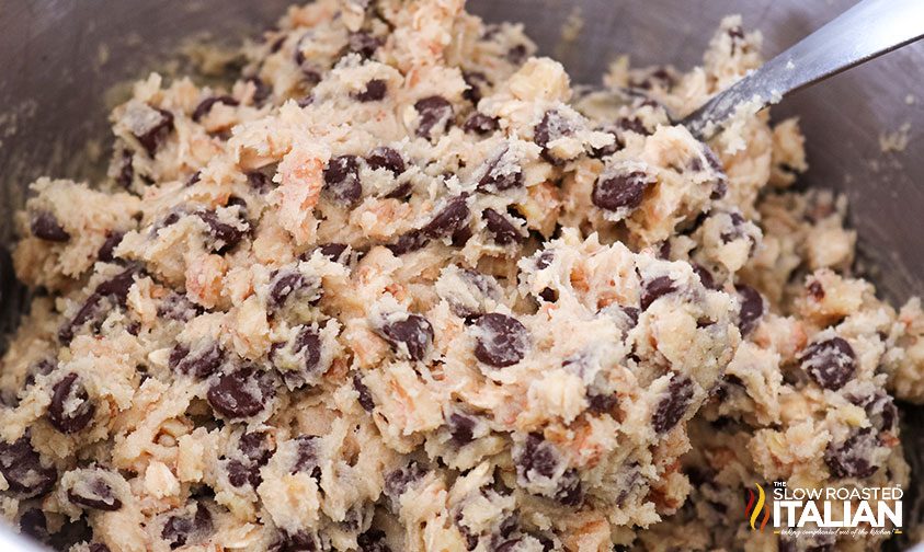 closeup: walnut chocolate chip cookie dough in bowl with spoon