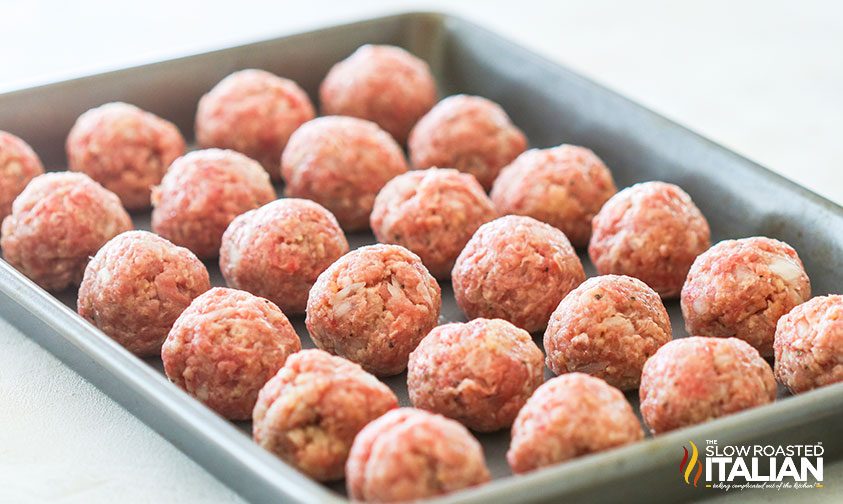 uncooked meatballs in baking pan