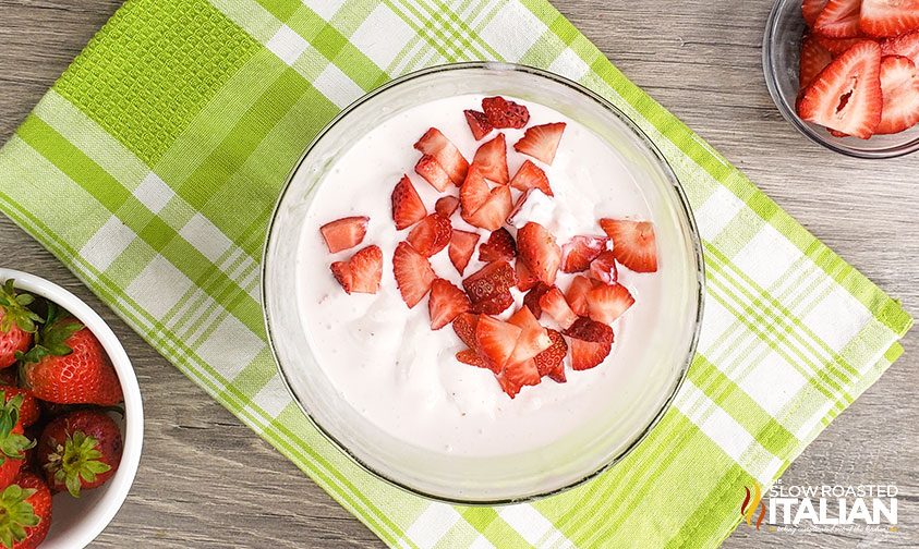 melted ice cream and fresh strawberries combined in mixing bowl