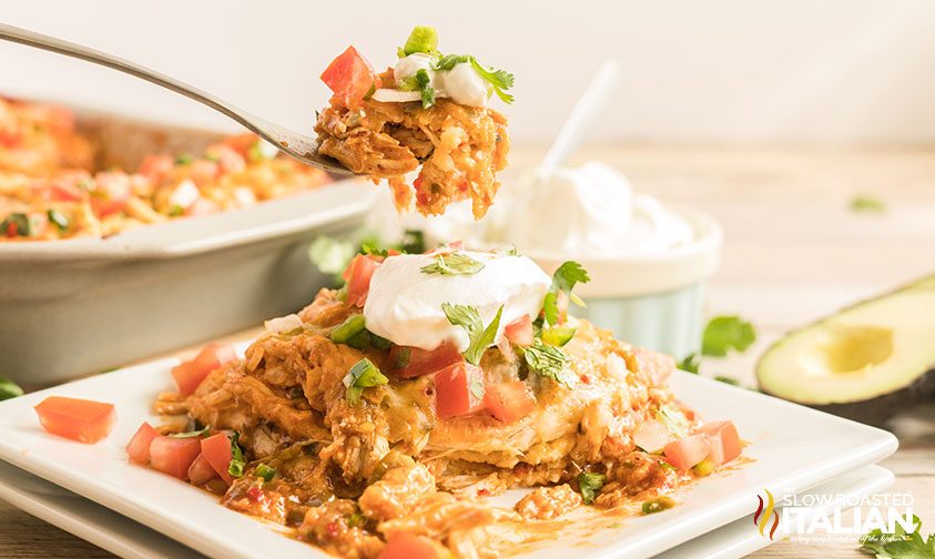 forkful of spicy chicken casserole above plated serving