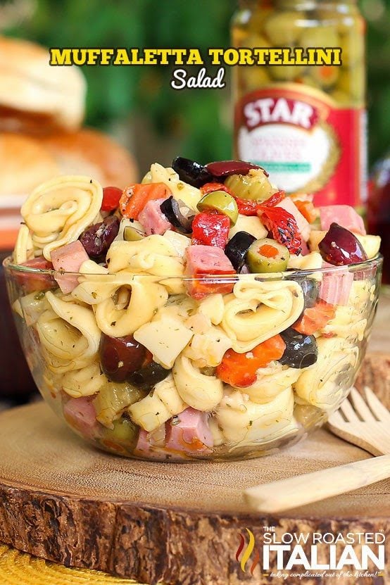 titled (shown in glass serving bowl) muffaletta tortellini salad