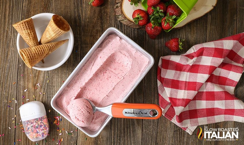 no churn strawberry ice cream on table with cones and ice cream scoop