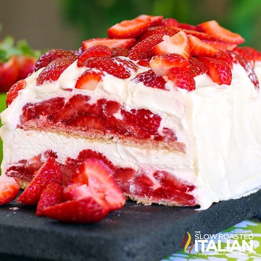 no bake strawberry cake topped with whipped cream and strawberry slices