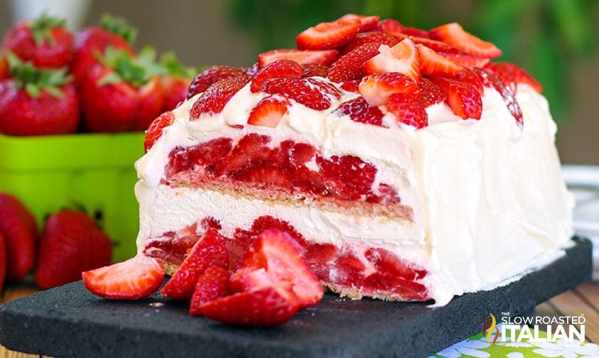 no bake strawberry cake topped with whipped cream and strawberry slices