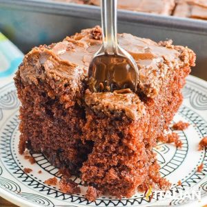 fork in piece of chocolate fudge cake on a plate