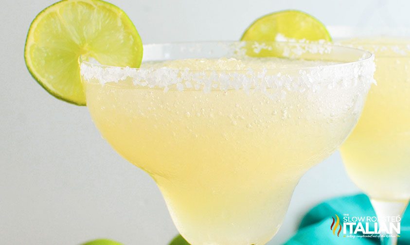 frozen margarita in glass garnished with slice of lime