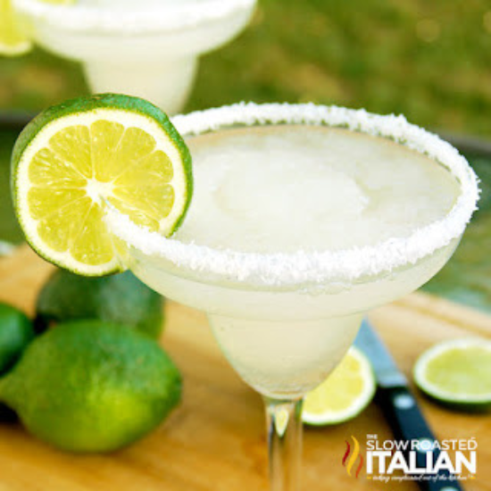 classic frozen margarita in salt rimmed glass with lime slice