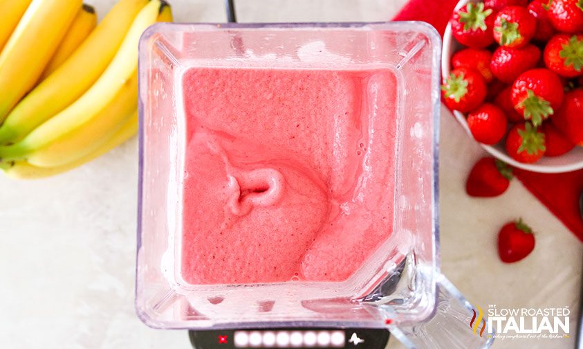 blending strawberries into frozen banana ice cream