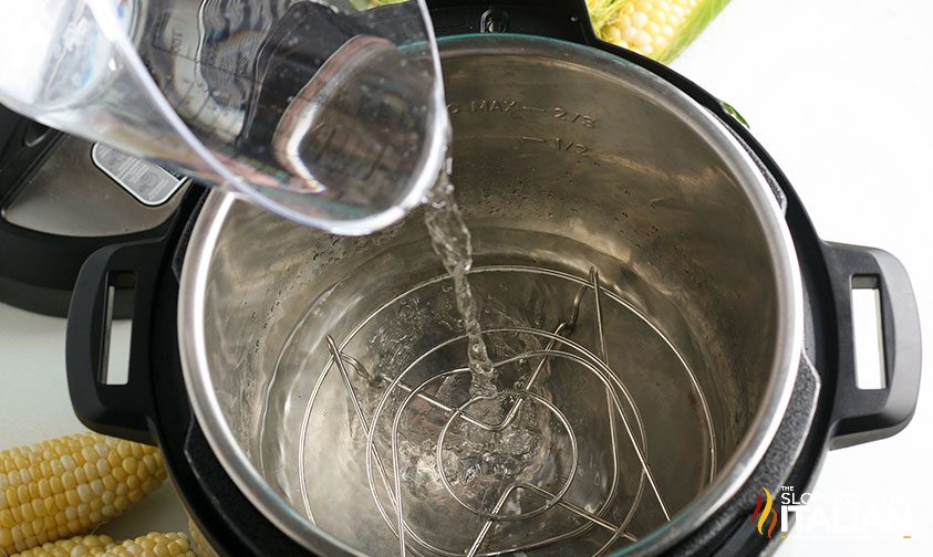 Instant Pot Corn on the Cob pouring water into pot