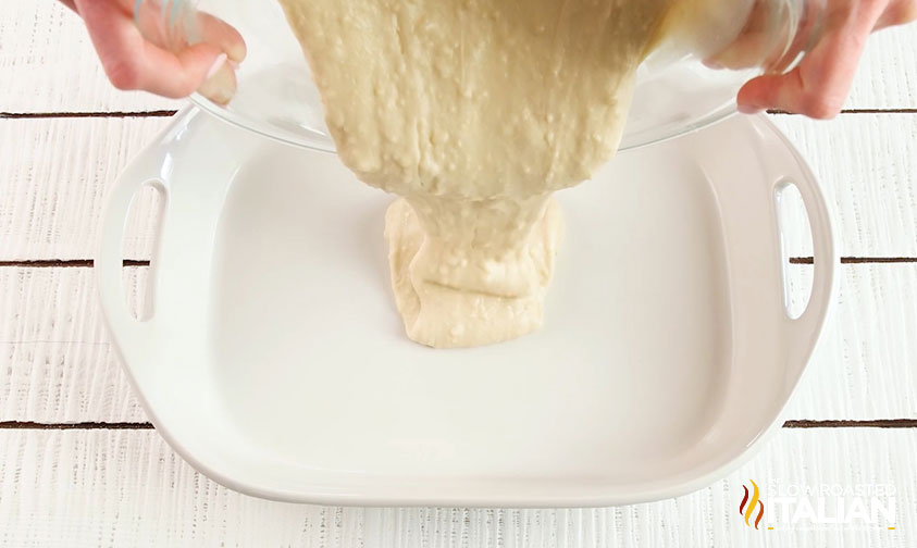 pouring dump cake in baking dish.