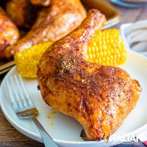 smoked chicken quarters on plate with corn